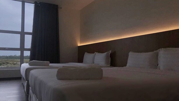 A hotel room with two beds, a large window, and a view of the outdoors. - Place2Stay Business Hotel @ Metrocity (Kuching)