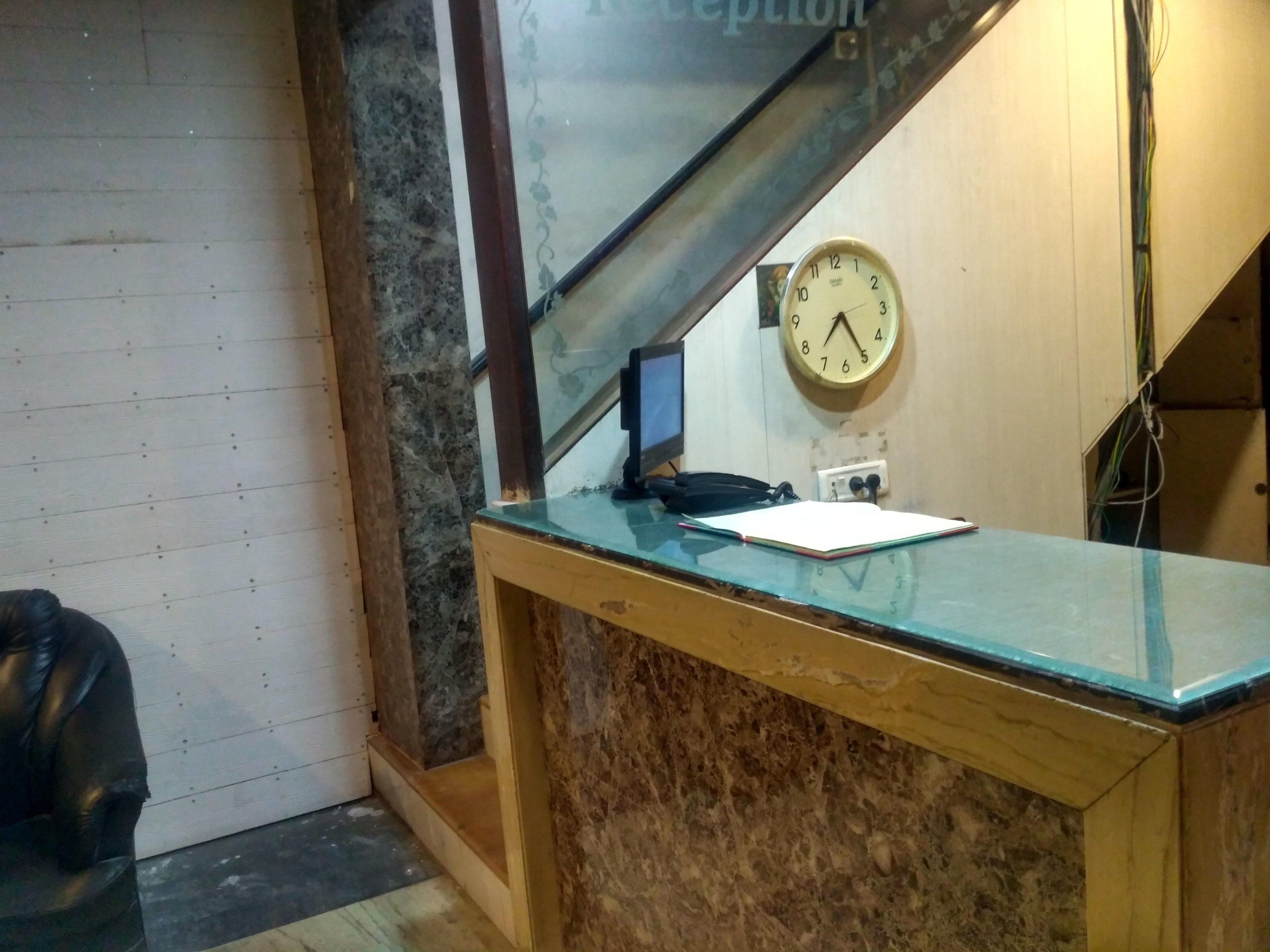 A reception desk with a clock, a phone, and a notepad.
