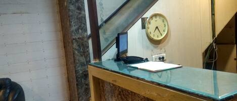A reception desk with a clock, a phone, and a notepad.