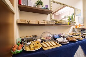 Una mesa de buffet con diferentes alimentos y una figurita decorativa de rana.