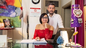 A hotel reception desk with a clock, a 'No Smoking' sign, and a Bounty poster. - Hotel Eriale (Rimini)