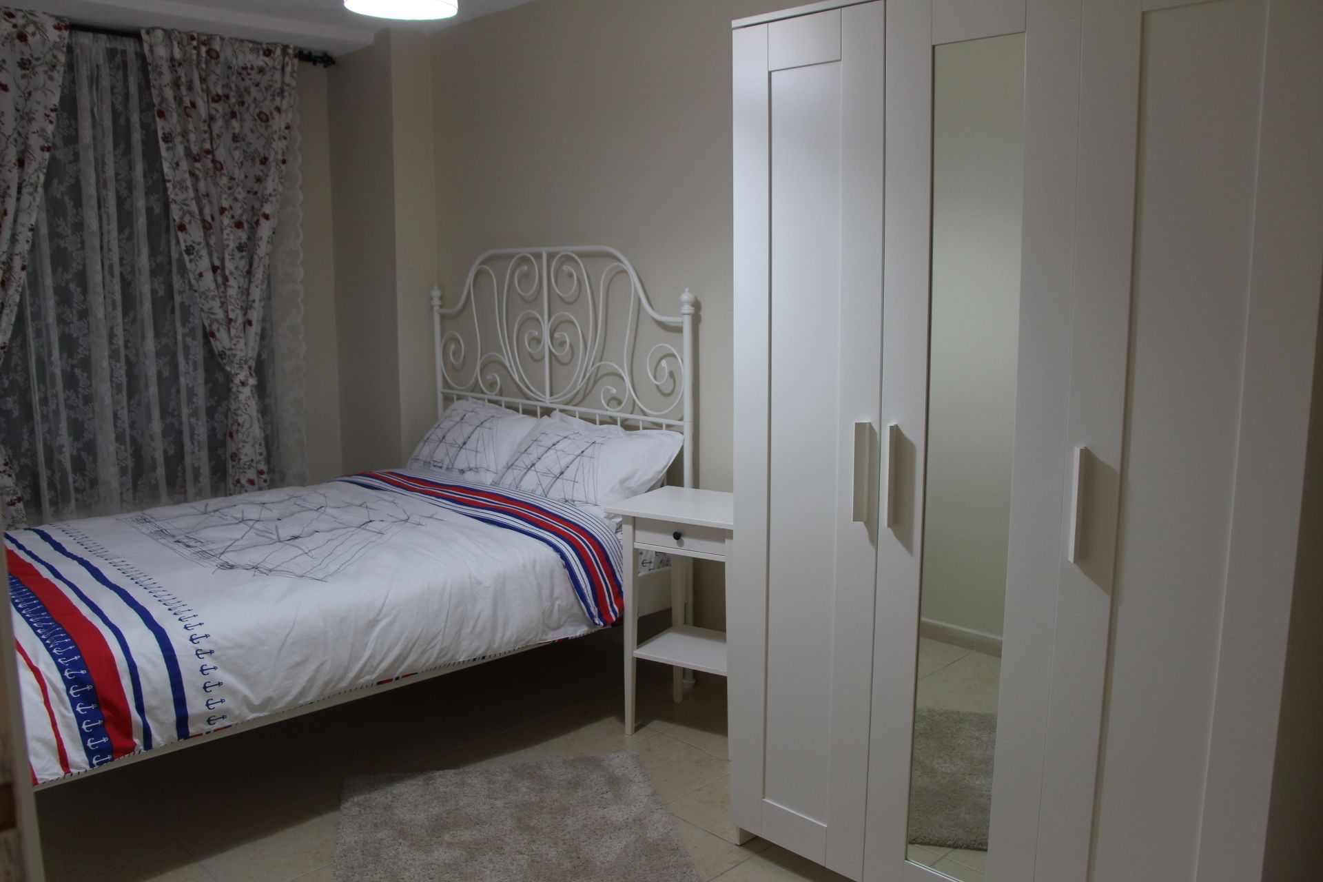 A bedroom with a bed, a wardrobe, and a desk.