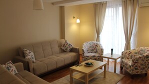 A living room with a sofa, two armchairs, a coffee table, and a lamp. - Kinzi House (Çanakkale)