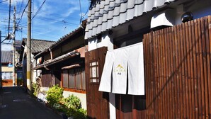 A traditional Japanese building with wooden sliding doors and a tiled roof. - Chika Odoru (Kyoto)