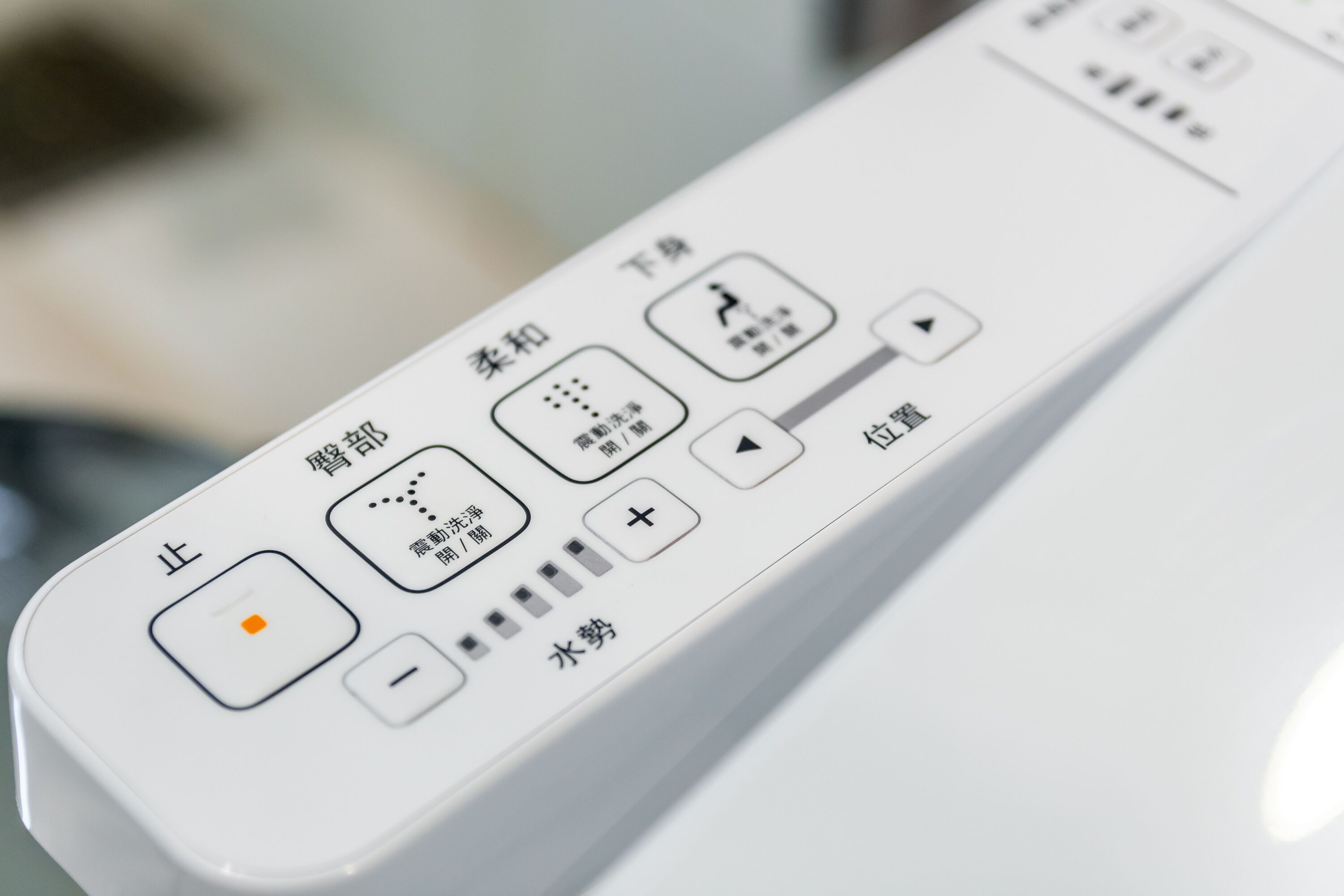 A white remote control with Japanese text and symbols.