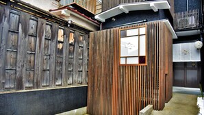 A traditional Japanese-style entrance with wooden sliding doors and a small window. - Chika Yusen (Kyoto)