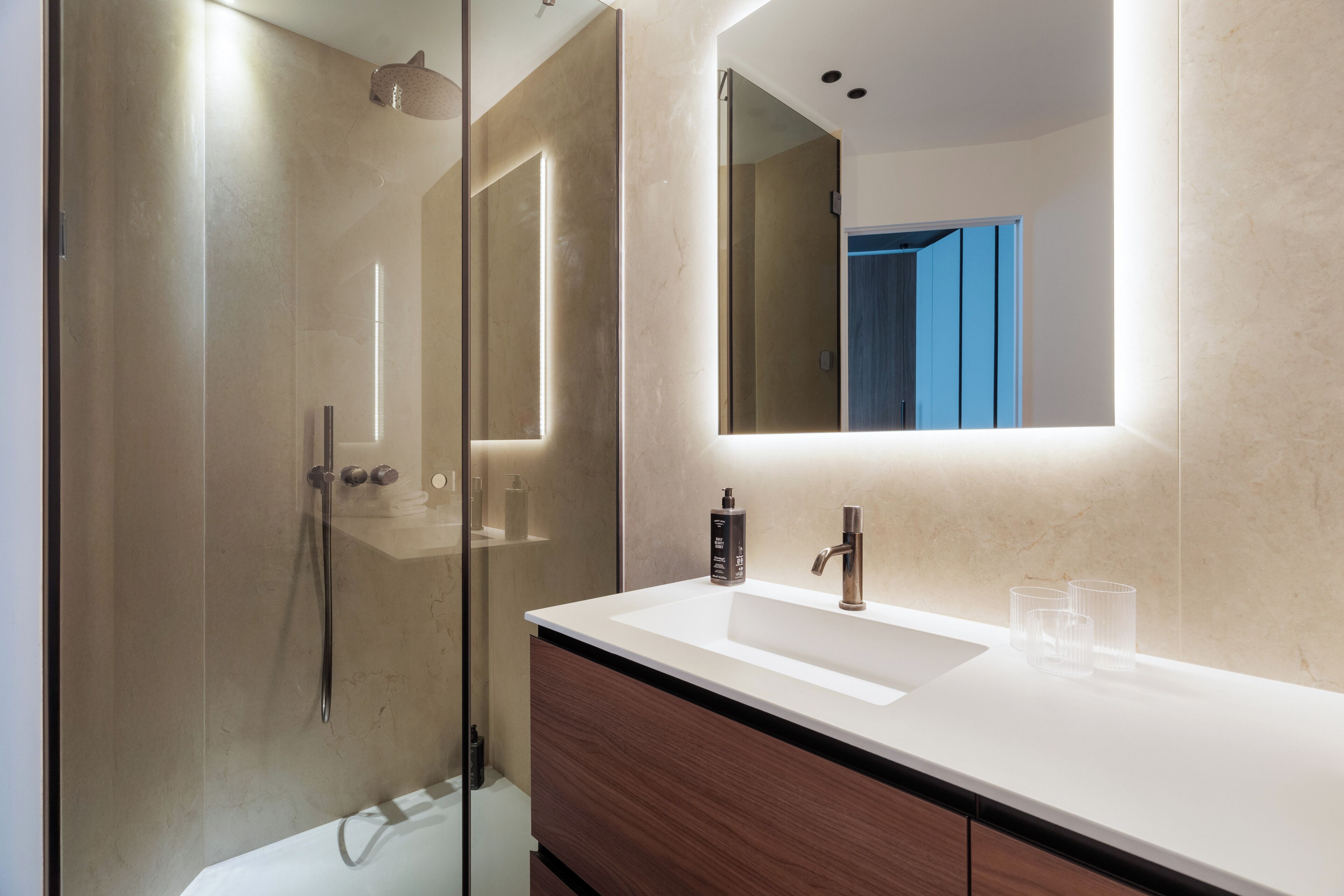 Een moderne badkamer met een douchecabine van glas, een wit wastafelmeubel met spiegel en houten opbergkasten.