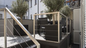 A balcony with outdoor furniture, a metal railing, and a view of the street. - Brera Apartments in City Center (Milan)