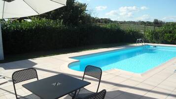 Outdoor pool, a natural pool, pool umbrellas, sun loungers