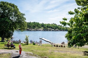 A lakeside park with a dock, benches, and a statue.