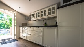 A kitchen with white cabinets, a microwave, and a sink.