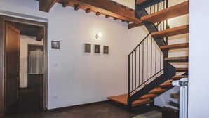 A staircase with wooden steps and black railings, leading to an upper floor. - Agriturismo Eutopia (San Leo)