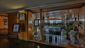 A hotel lobby with a restaurant visible through a glass wall. - Hôtel Le Corbusier (Marseille)