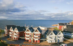A coastal residential area with multiple two-story houses featuring balconies and a view of the sea. - Amazing apartment in Rechlin with sauna (Rechlin)
