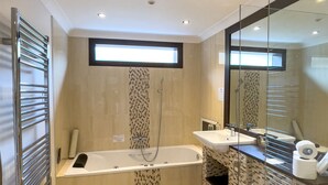 A modern bathroom with a freestanding bathtub, a toilet, and a sink. - Haddon House Hotel (Bridport)