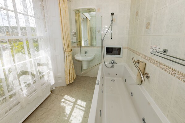 Une salle de bain avec une baignoire, un lavabo et une douche.