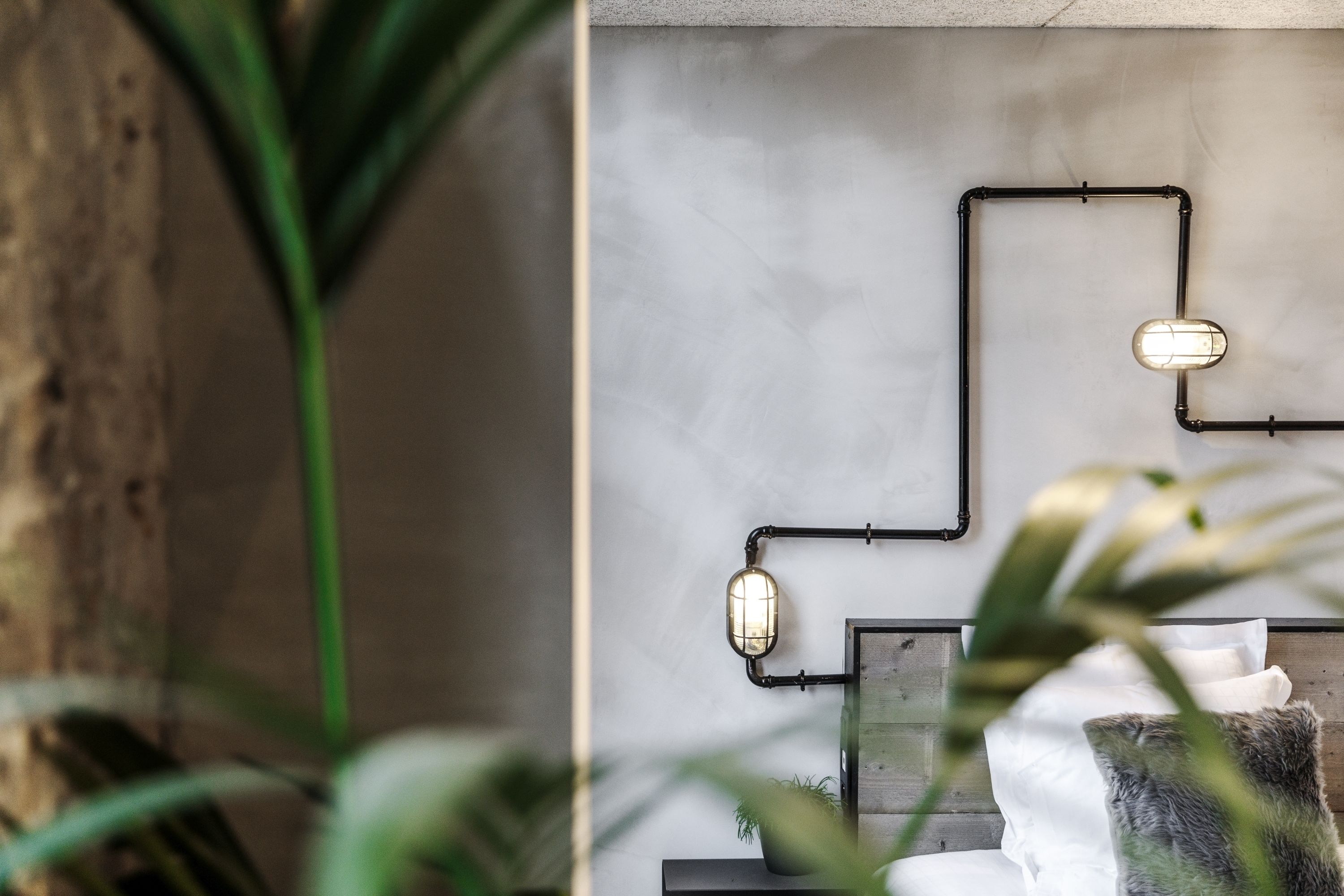 Una habitación moderna con diseño minimalista, que presenta una lámpara de pared y una pared decorativa de madera.