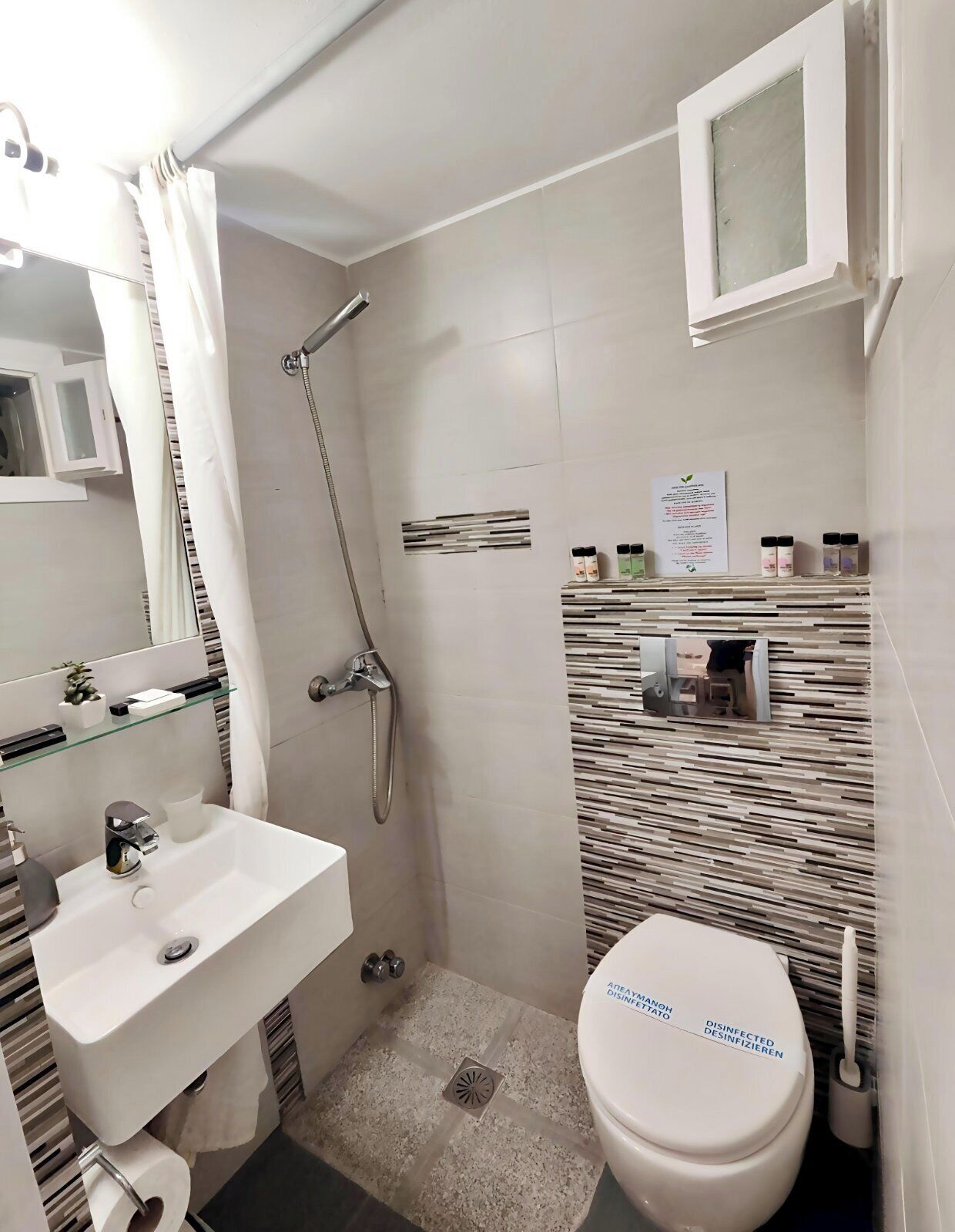 Une petite salle de bain comprenant une douche, un lavabo et des toilettes.