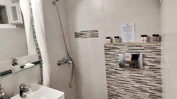 Une petite salle de bain comprenant une douche, un lavabo et des toilettes.