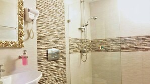 A bathroom with a sink, toilet, and shower. - Tinos Heritage Plateia (Tinos)