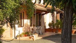 A house with a patio, outdoor furniture, and potted plants. - Agriturismo Al Vermigliano (Grosseto)