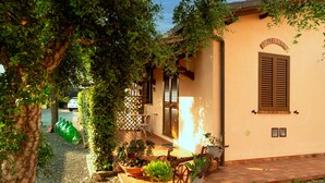 A house with a patio, potted plants, and a bicycle. - Agriturismo Al Vermigliano (Grosseto)
