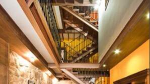 A spacious interior with a staircase leading to an upper level, a cozy seating area with a patterned rug, and a fireplace. - Hotel O Portelo Rural (Allariz)