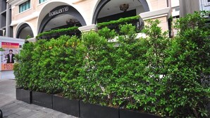A building with arched entrances and a well-maintained garden area. - Aspira Skyy Sukhumvit 1 (Bangkok)