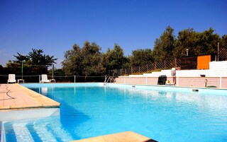 Una piscina al aire libre de temporada, sombrillas