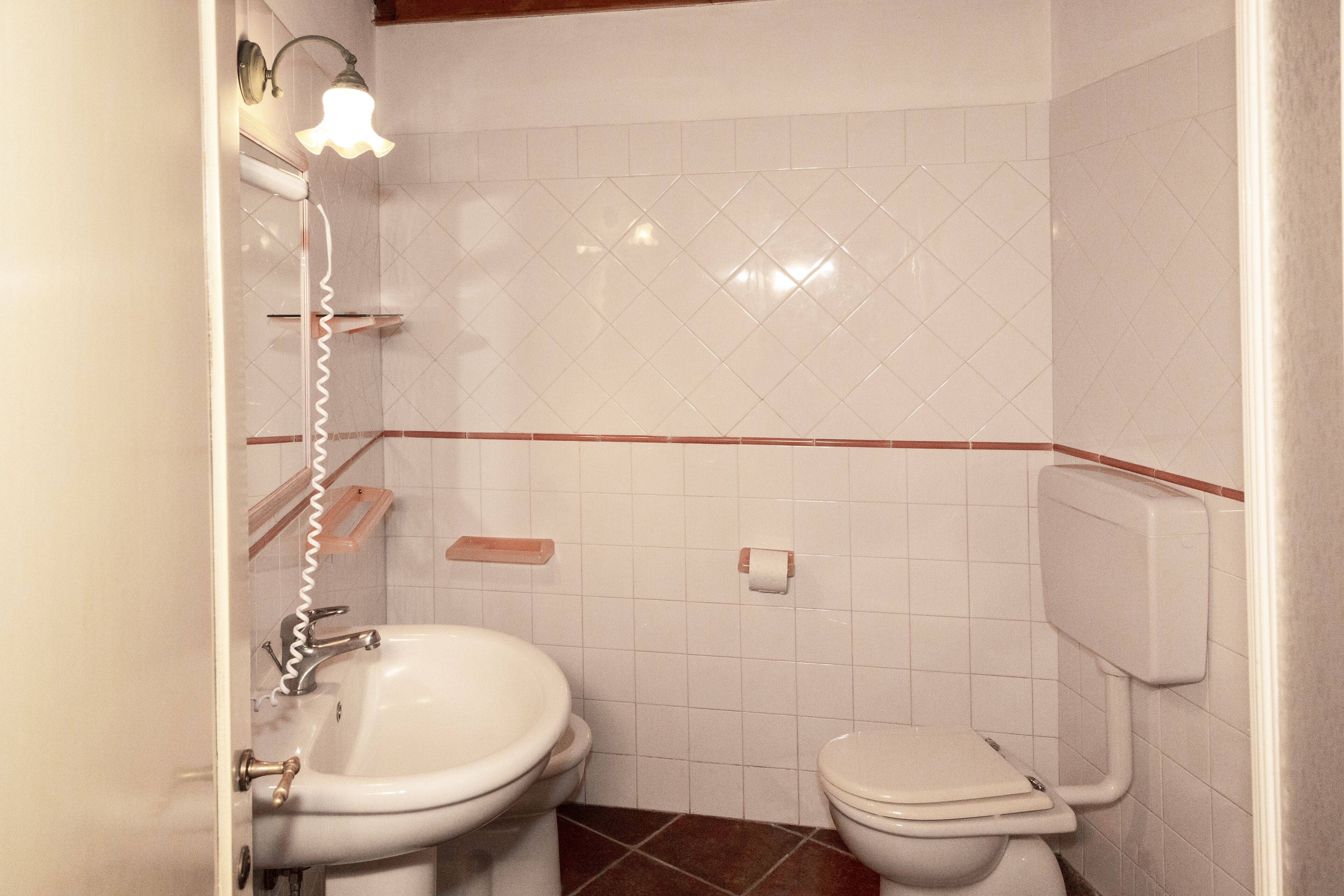 Un bagno con lavandino, WC e doccia.