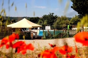 Piscina a l'aire lliure de temporada, para-sols i gandules 