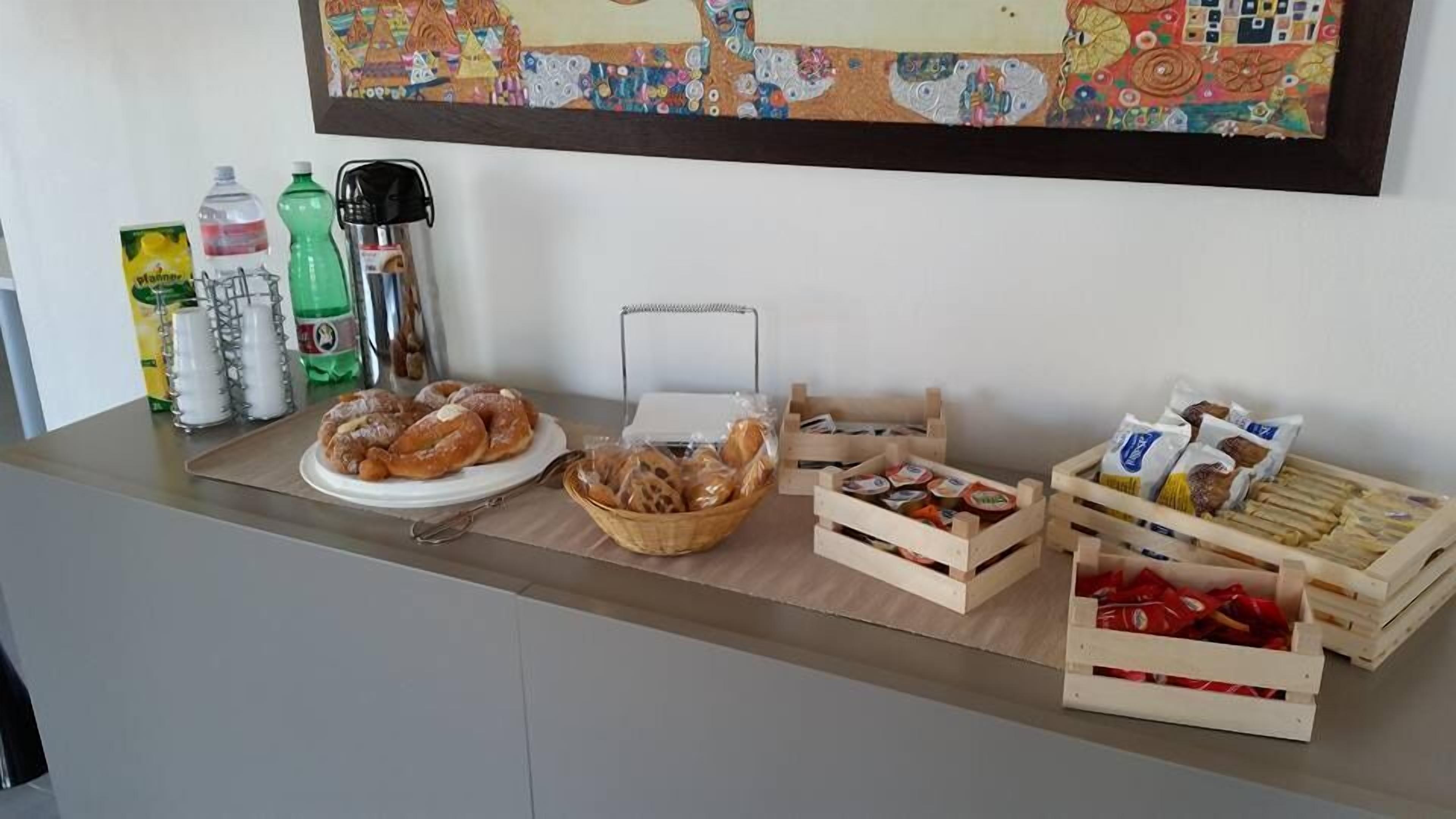A breakfast buffet with pastries, bread, and condiments.