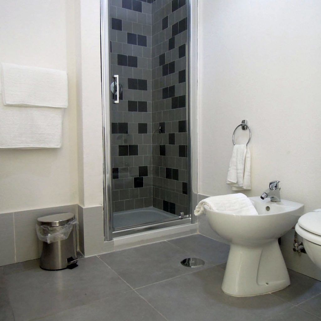 Une salle de bain avec une douche à parois de verre, des toilettes et un bidet.