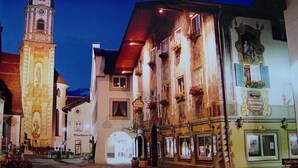 Un edificio histórico con una torre de reloj, un restaurante y un letrero que dice 'Hotel-Gasthof Alpenrose'.
