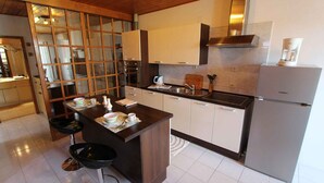 A modern kitchen with a central island, stainless steel appliances, and a large window with a view.