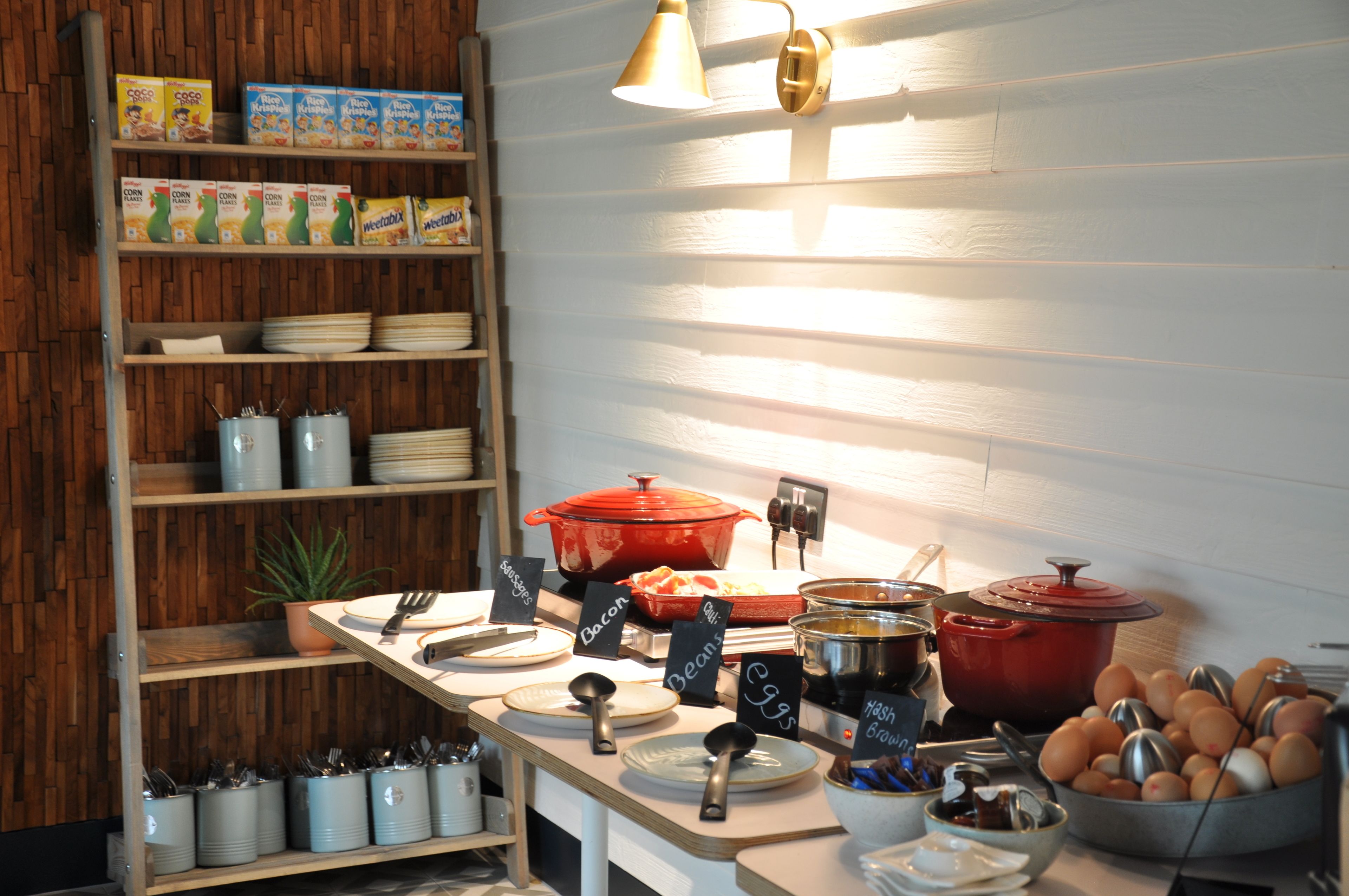 A breakfast buffet with various food items and cooking utensils.
