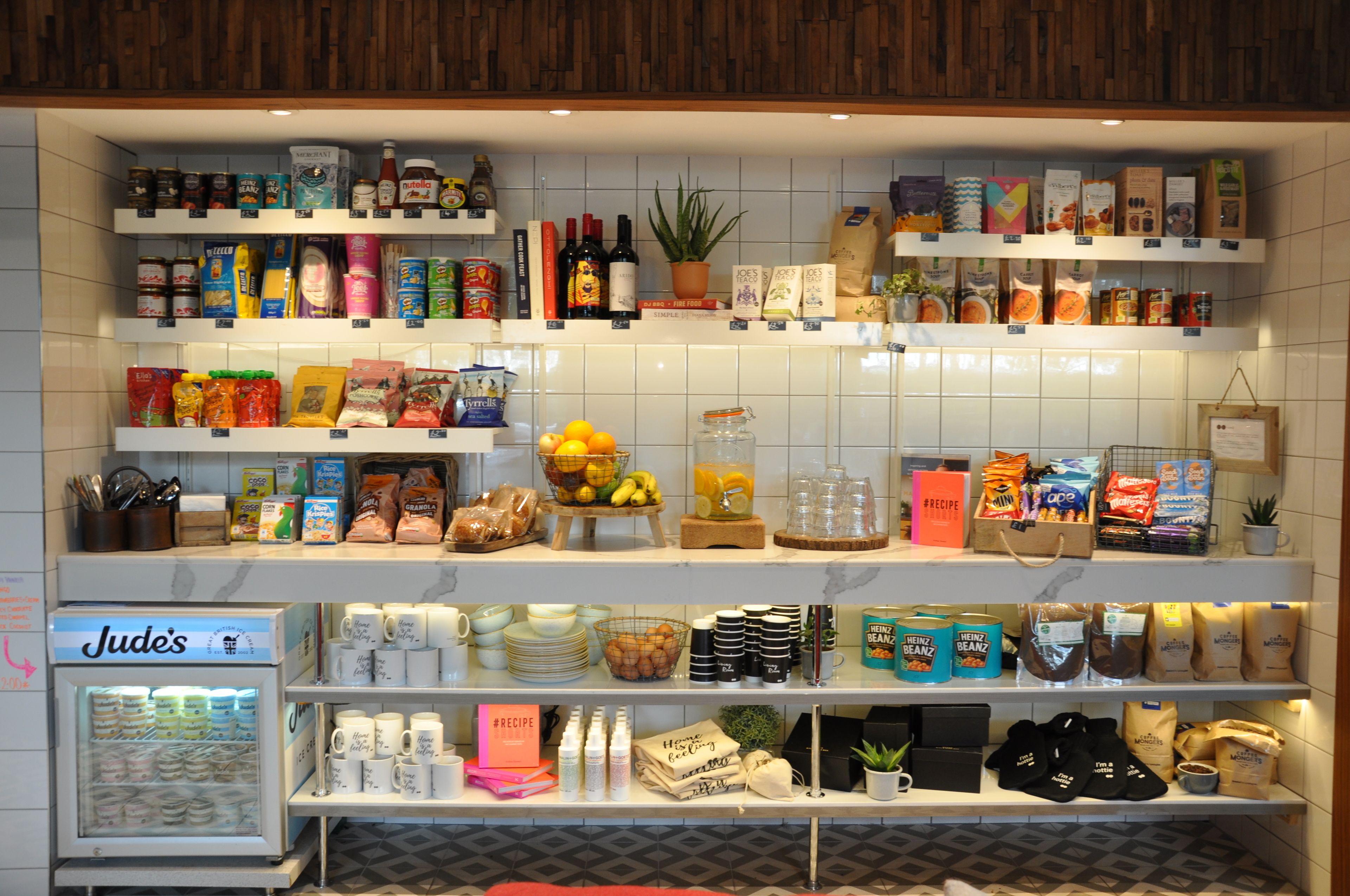 A well-organized grocery store with shelves stocked with a variety of products including snacks, beverages, and household items.