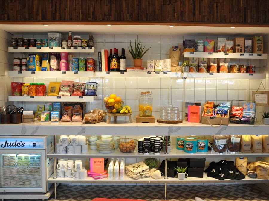 A well-organized grocery store with shelves stocked with a variety of products including snacks, beverages, and household items.