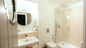 A bathroom with a sink, toilet, and shower.