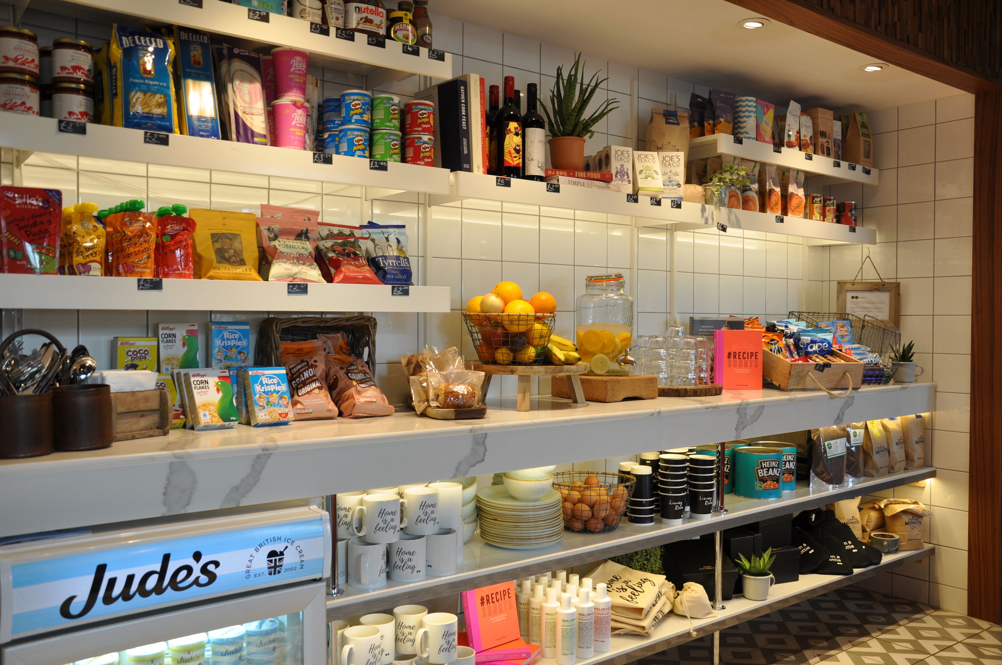 A well-organized store with shelves stocked with various food items, including snacks, condiments, and beverages.