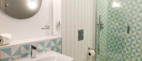 A bathroom with a white sink, a toilet, and a glass-enclosed shower.