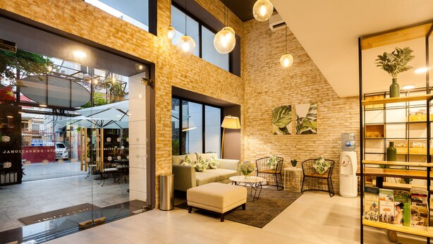 A modern interior with a brick wall, a sofa, a coffee table, and a bookshelf. - La Regatta Boutique Residences (Ho Chi Minh City)