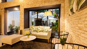 A modern interior with a brick wall, a sofa, a round table, and potted plants. - La Regatta Boutique Residences (Ho Chi Minh City)