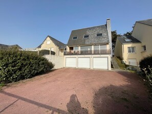 A residential property with a driveway leading to a garage, surrounded by hedges and other houses. - Seafront villa with garden and free Wifi (Saint-Pair-sur-Mer)