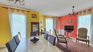 Uma área de refeições com mesa, cadeiras e um candelabro.