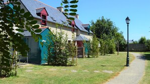 Une maison avec un toit en pente, une cheminée rouge et un chemin qui y mène.