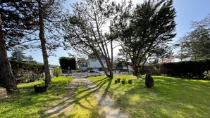 A pathway leading to a house surrounded by trees and grass. - Beachside Villa with Garden, Free Wifi & BBQ – Close to Shops & Attractions (Jullouville)