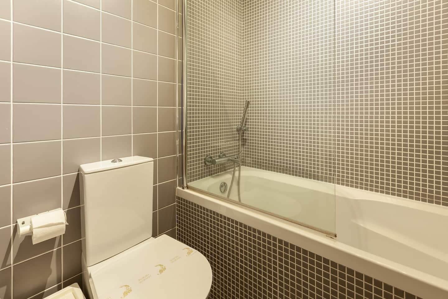 Un baño con inodoro, ducha y bañera.