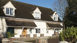 A two-story house with a brick facade, white trim, and a sloped roof.