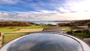 A panoramic view of a landscape with a body of water, hills, and a clear sky. - Shandon Hotel & Spa (Portnablagh)
